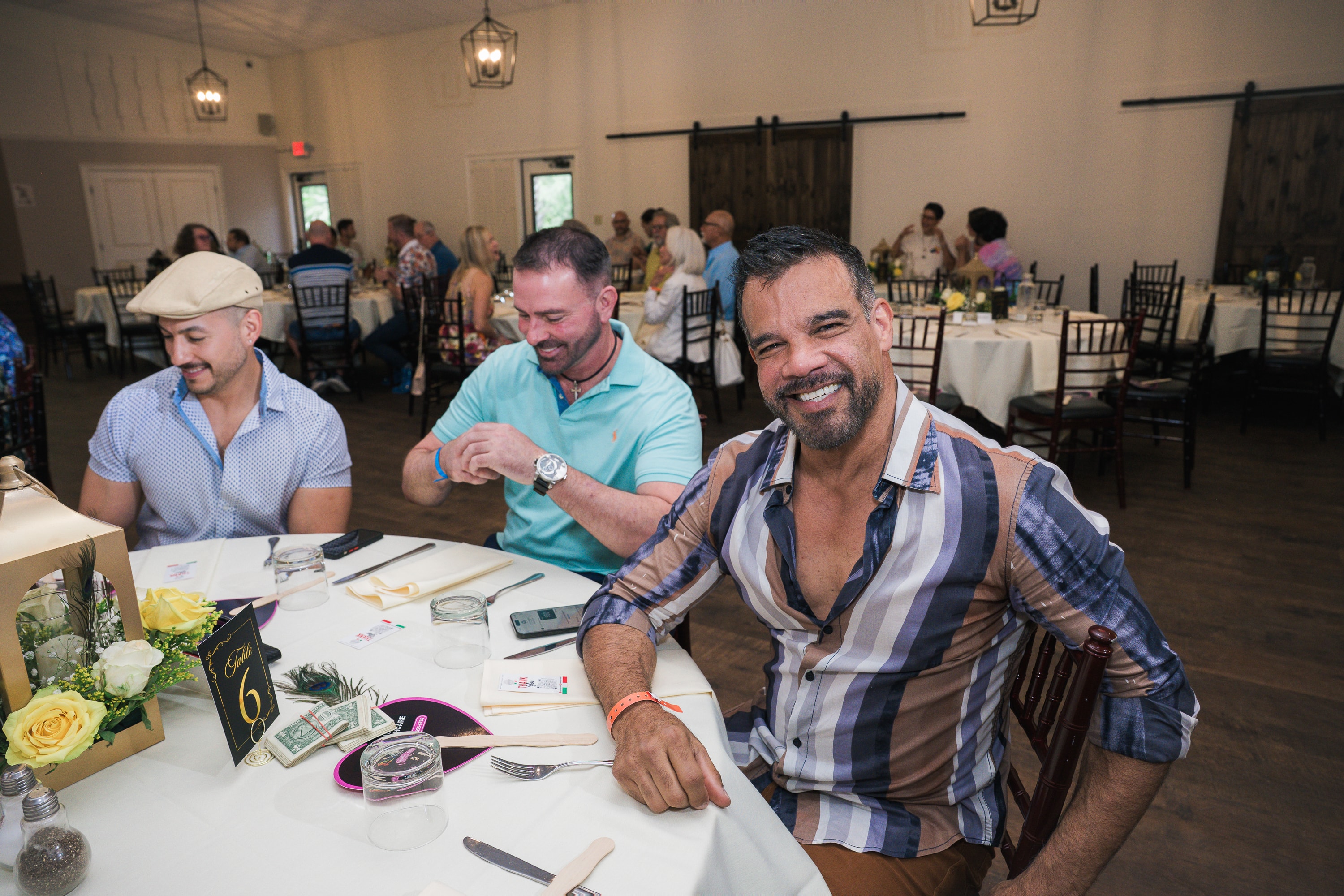 Guests laughing at their table at Peacocks & Divas 2025
