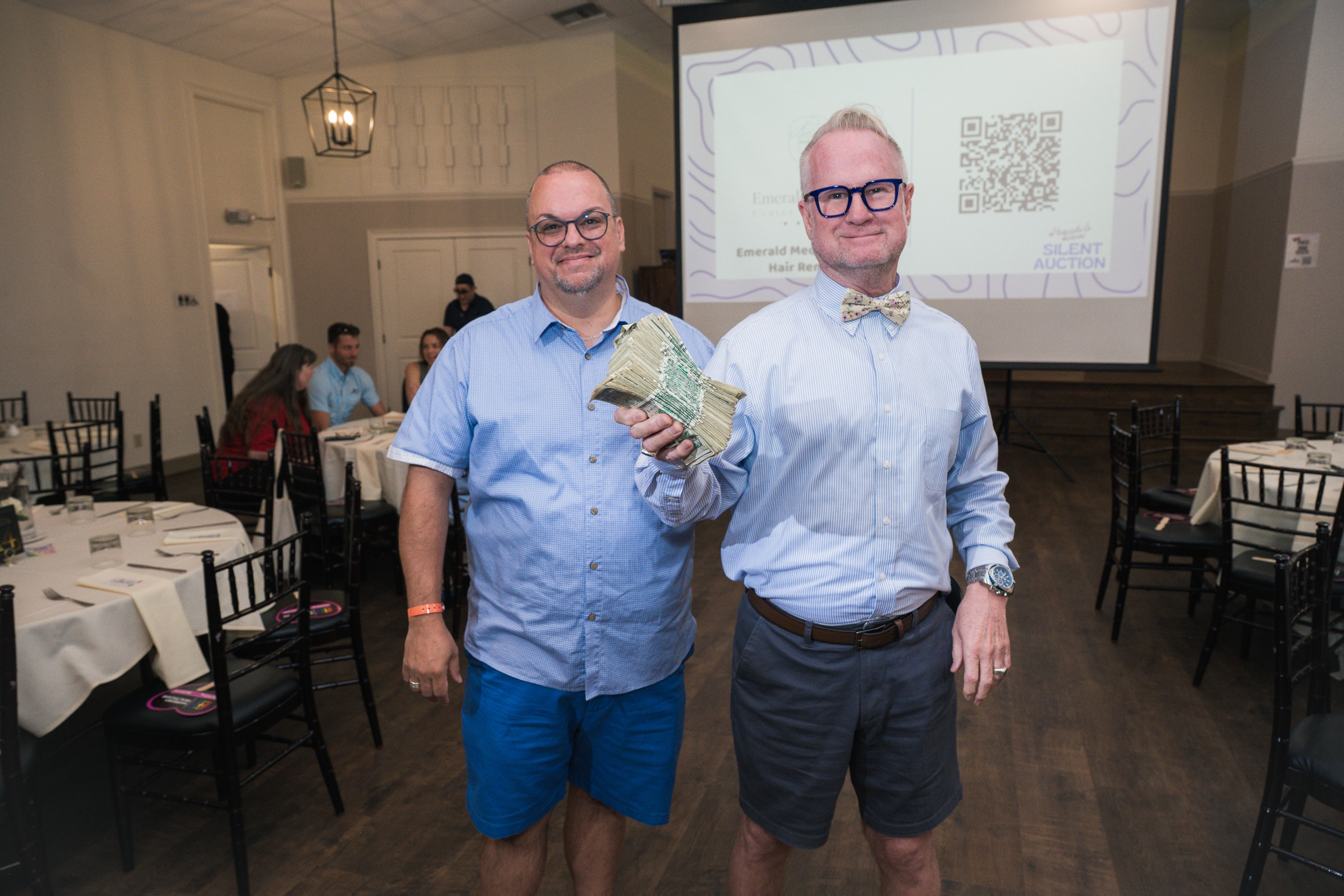 Two guests at the silent auction at Peacocks & Divas 2025