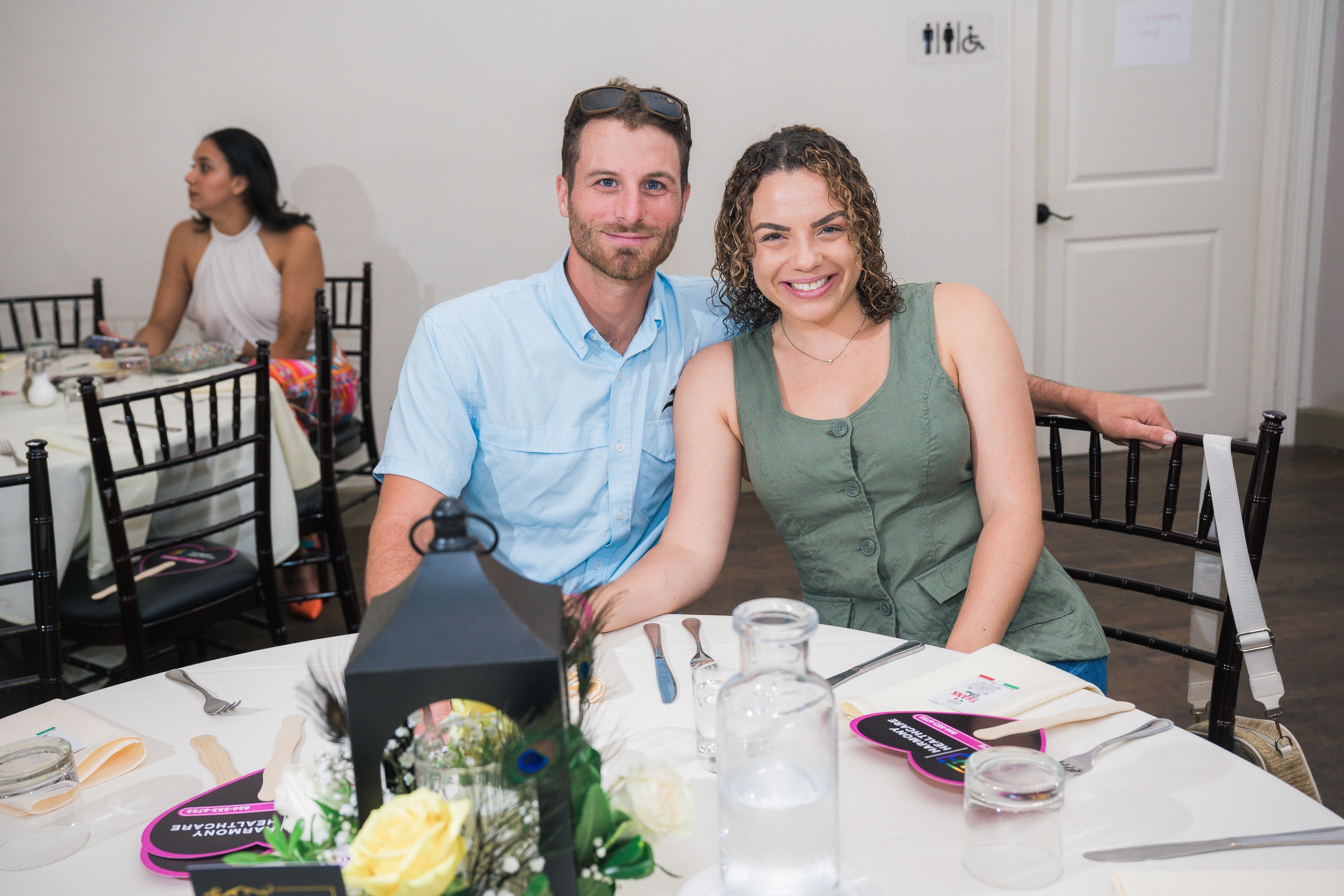 Couple smiling at their table at Peacocks & Divas 2025